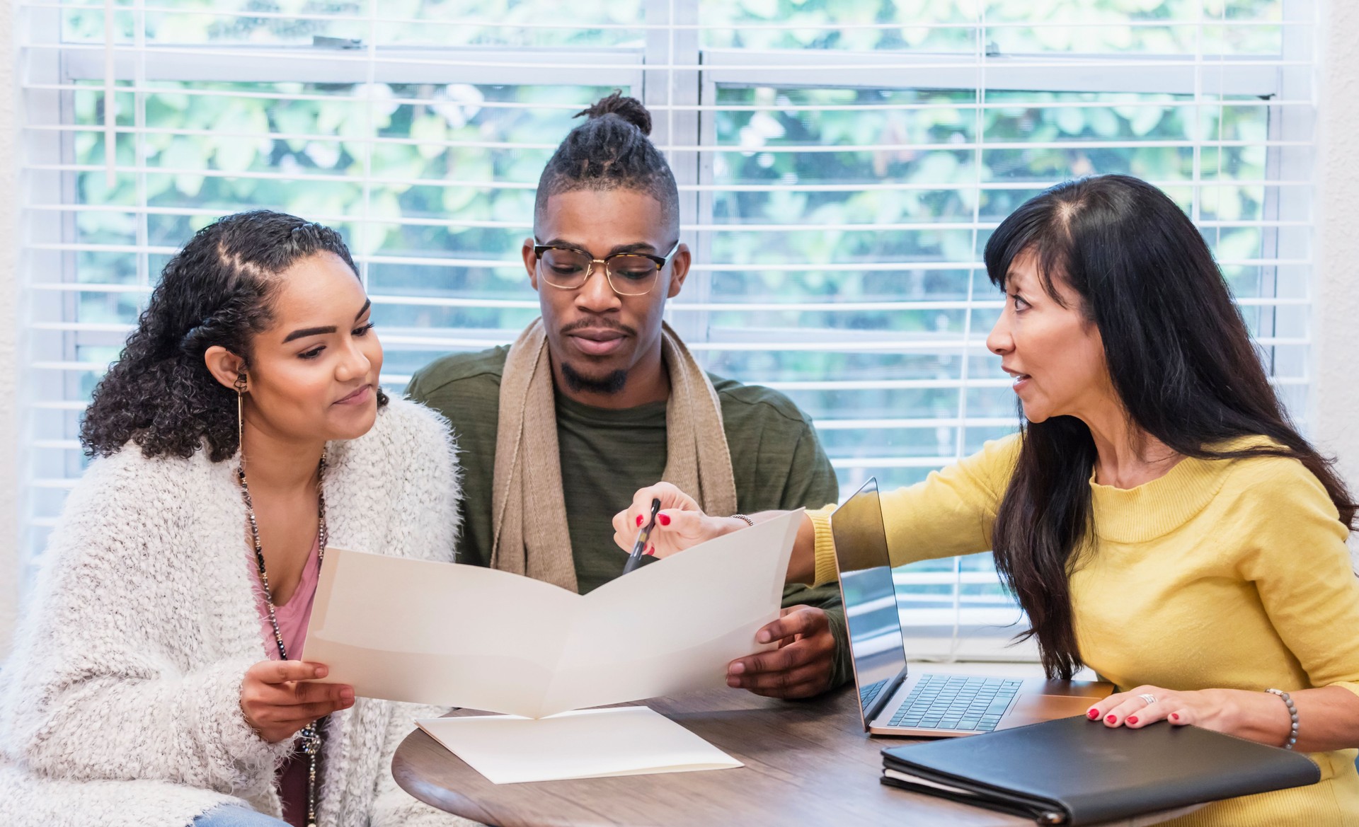 Young couple with advisor, signing paperwork